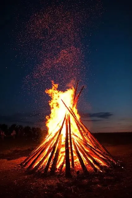 Bonfire at dusk with dramatic particle spray, photographic, dramatic, warm