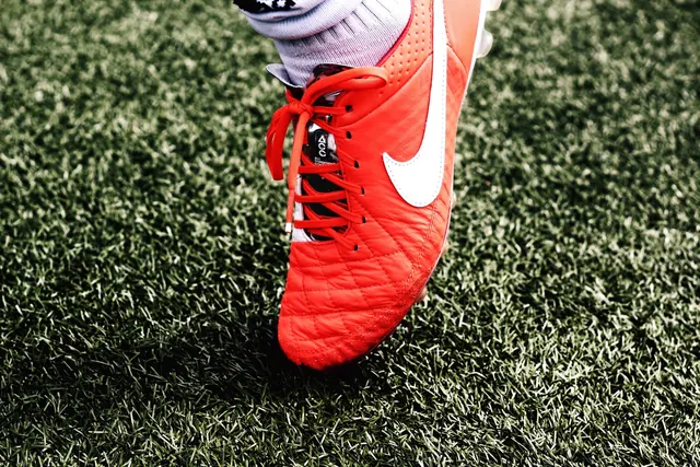 Nike soccer cleat on grass field, photographic, sports, vibrant