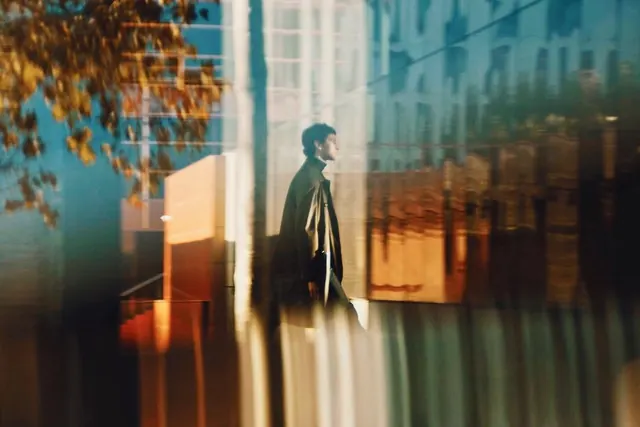 Urban Figure with Architectural Glass Reflections, photographic, minimal, cool
