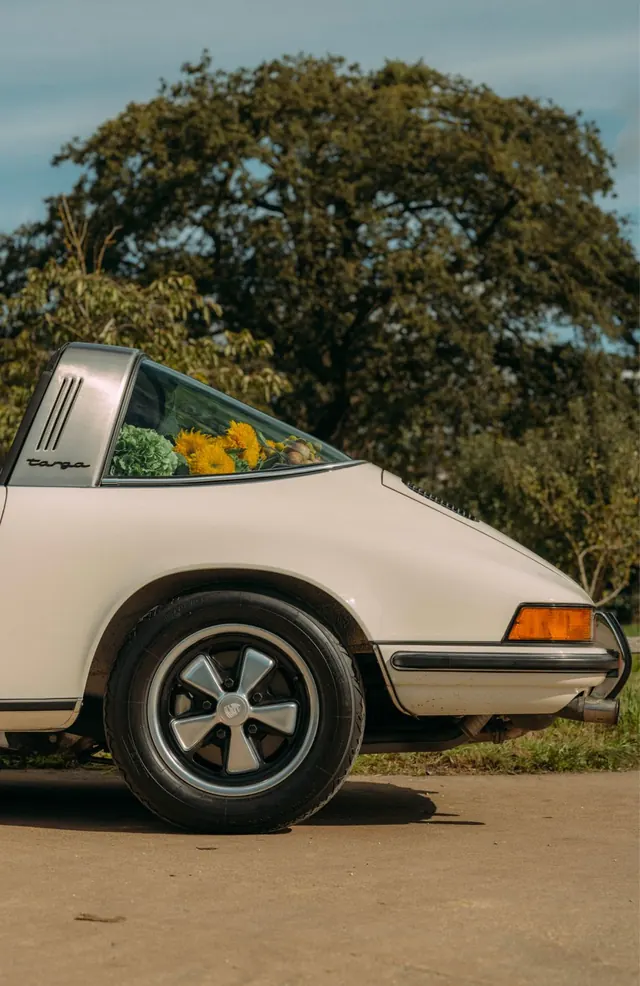 Vintage Porsche with flowers in back window, photographic, nostalgic, warm