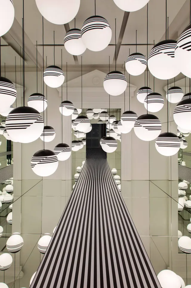 Pendant light installation creating visual rhythm, photographic, minimalist, warm