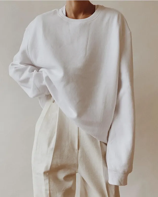 Oversized cream knitwear flat lay, minimal, photographic, light