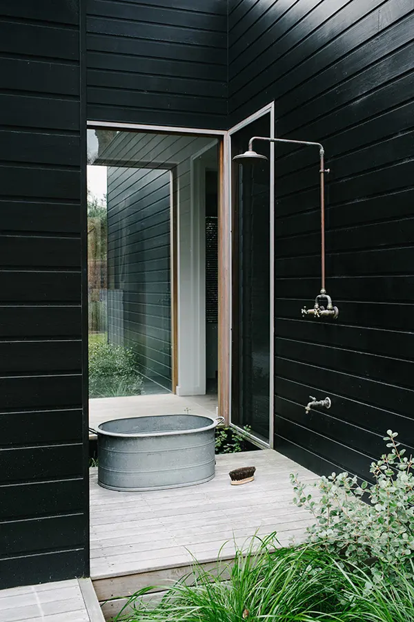 Modern black bathroom with galvanized soaking tub, photographic, minimal, dark
