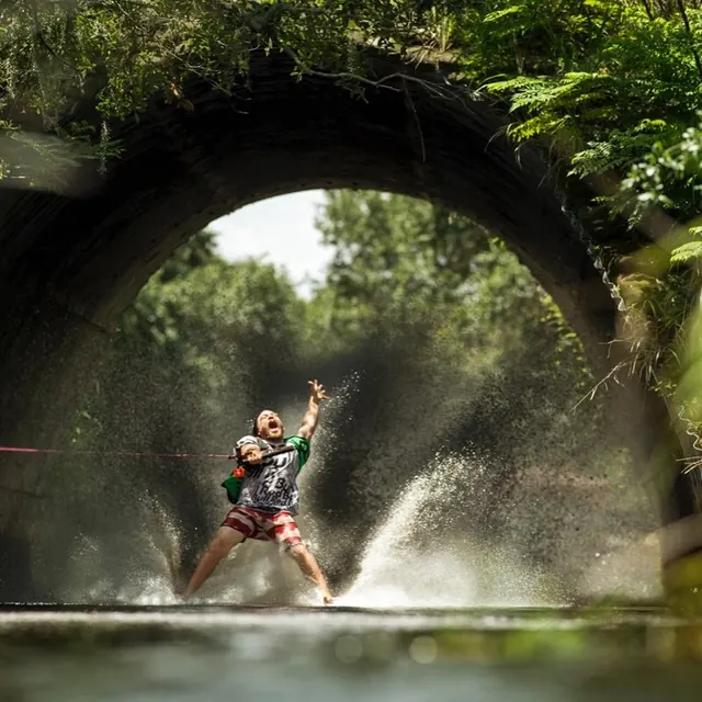 Person playing frisbee under stone archway, photographic, organic, vibrant