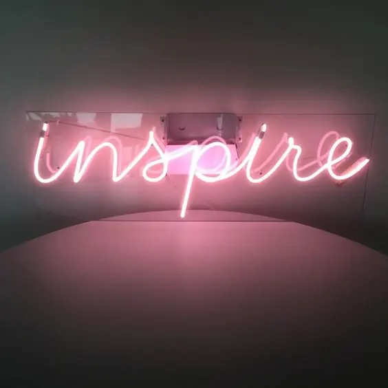 Pink neon 'inspire' sign on dark background, minimal, neon, vibrant