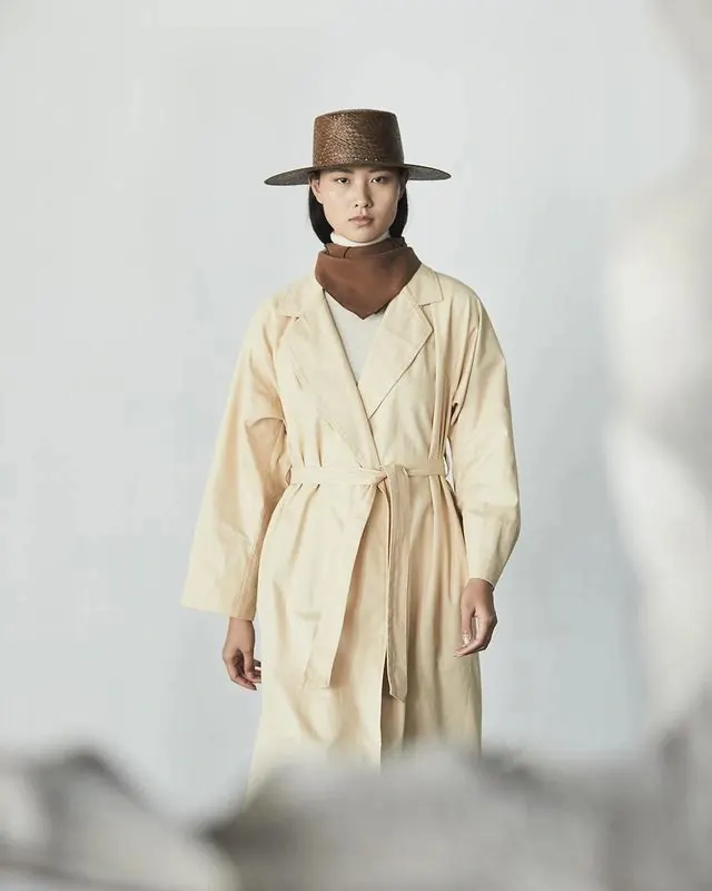 Fashion figure with hat and trench, photographic, editorial, warm