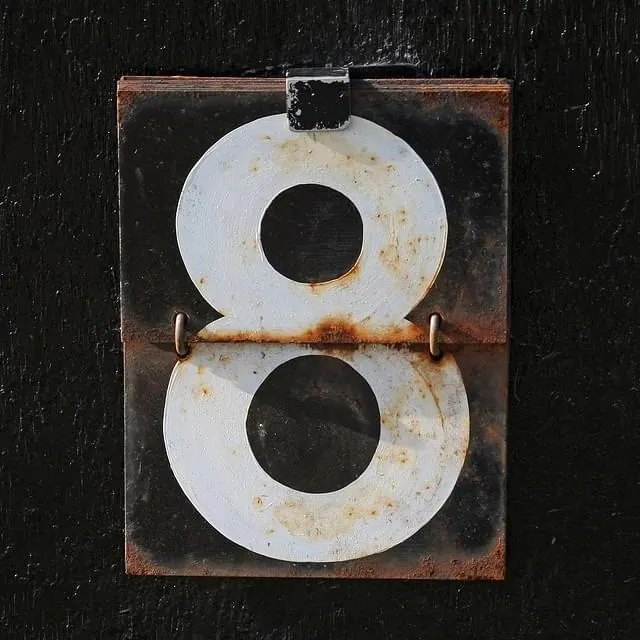 Weathered vintage sign with number 8, photographic, warm