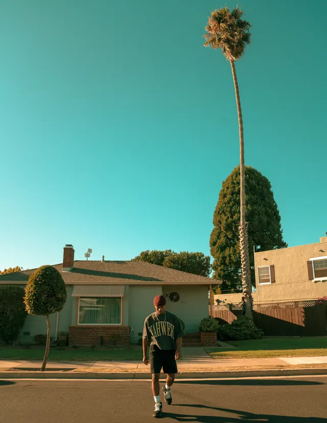 Suburban street running photograph with turquoise sky, photographic, retro, cool