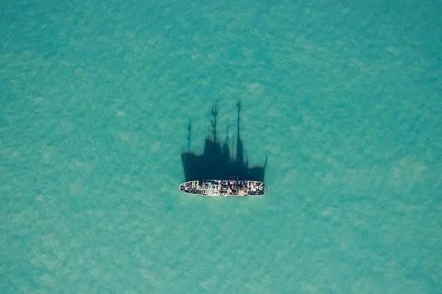 Aerial view of boat in turquoise water, photographic, minimal, light
