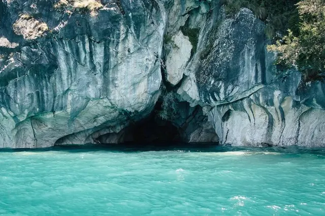 Turquoise sea cave at cliff base, photographic, editorial, cool