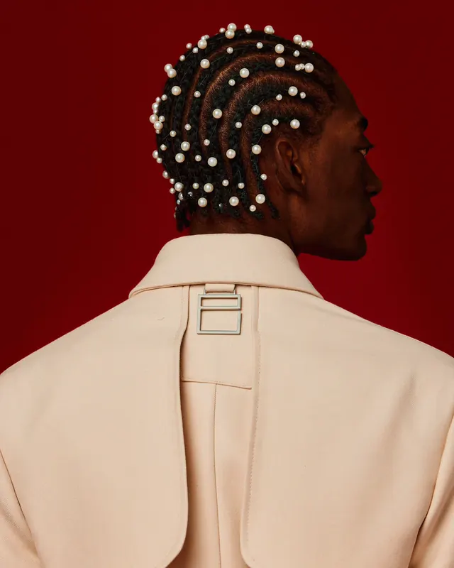 Portrait with pearl-beaded braids against crimson background, photographic, bold, vibrant