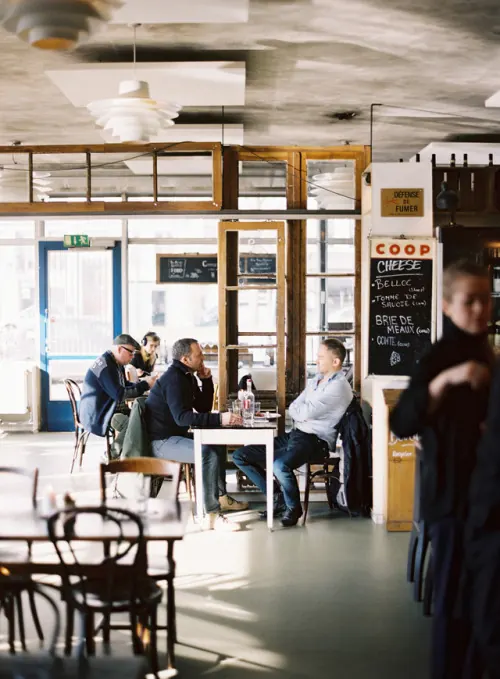 Bright interior restaurant or cafe with patrons and wooden details, photographic, warm