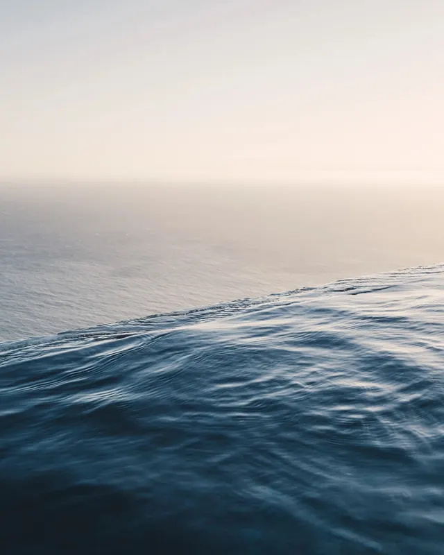 Ocean horizon at dusk with foreground ripples, photographic, minimal, muted