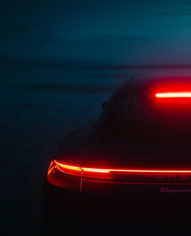 Porsche Taycan rear taillight at night, photographic, dark-mode, dark