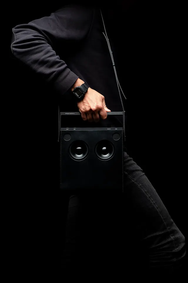 Black portable radio product on dark background, overhead studio shot, photographic, minimal, dark