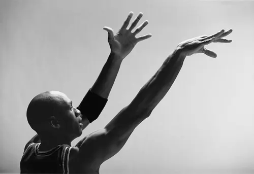 Silhouette of child with arms raised, photographic, minimal, monochrome