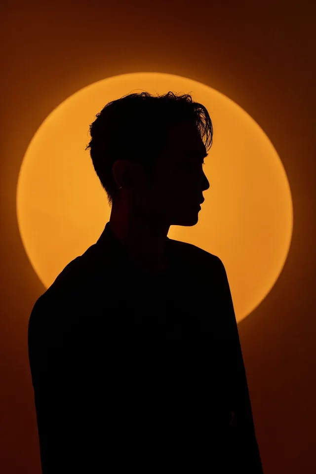 Portrait silhouette with large sun halo, photographic, minimalist, warm