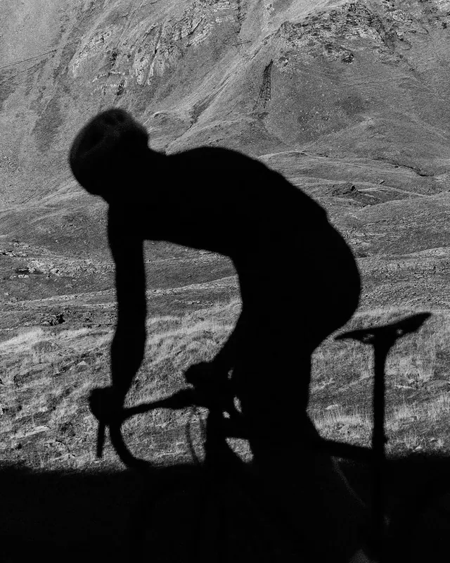 Cyclist silhouette in bright sunlight, photographic, dramatic, monochrome