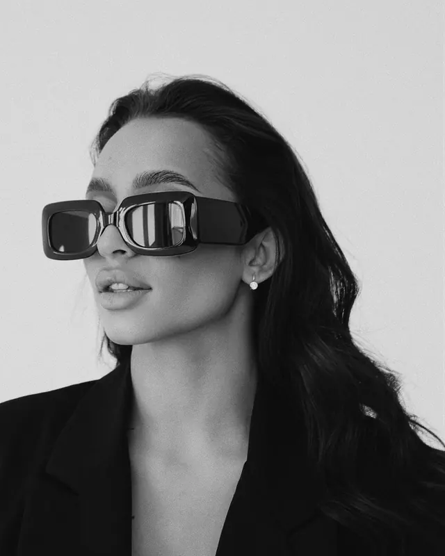 Person wearing geometric sunglasses, photographic, minimalist, monochrome