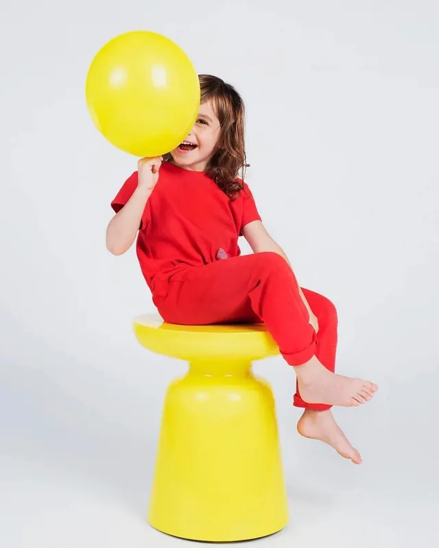 Child portrait with yellow props, photographic, playful, vibrant