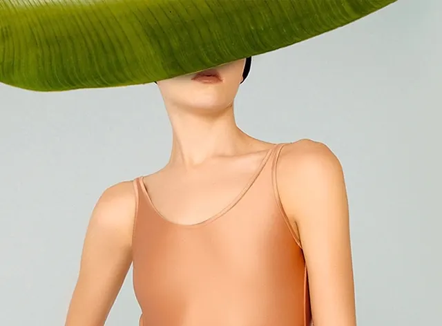 Woman with oversized green hat, photographic, minimal, earthy
