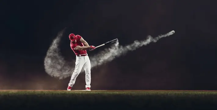 Baseball player mid-swing with dramatic dust effect, photographic, dynamic, dark