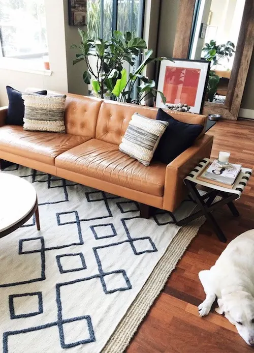 Mid-century living room with cognac leather sofa, photographic, minimalist, warm