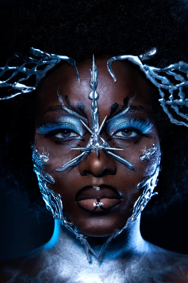 Portrait with blue body art and metallic face paint, photographic, playful, dark