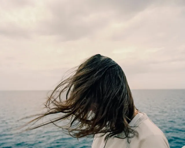 Person from behind overlooking ocean, photographic, cool