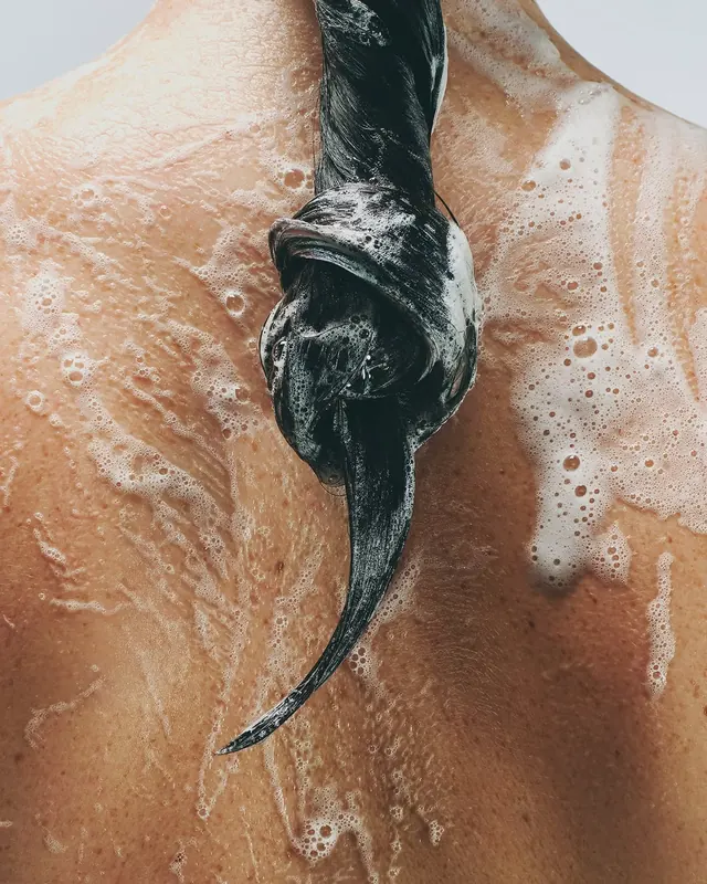 Snake being held in shower with water and bubbles, photographic, editorial, warm