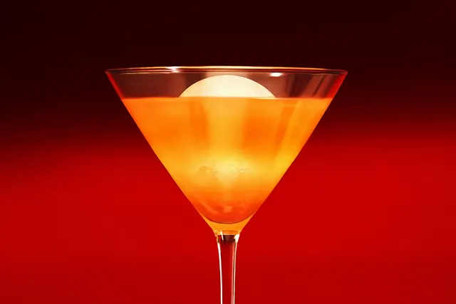 Amber cocktail with ice sphere, photographic, luxury, warm