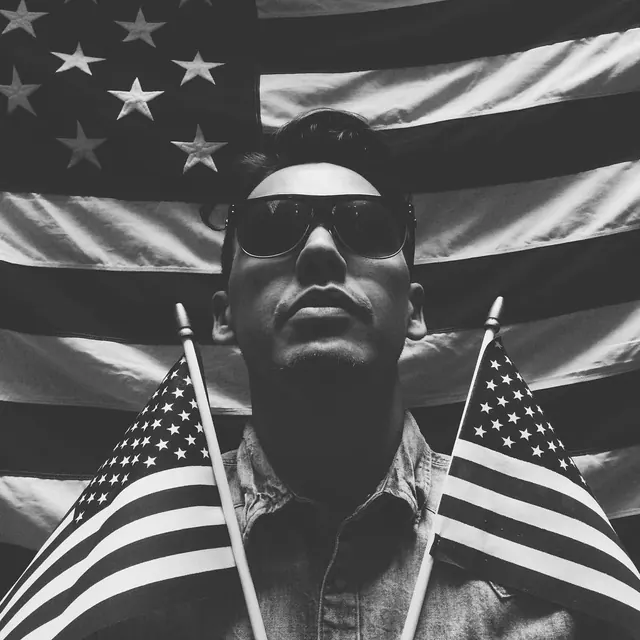 Patriotic portrait with flags and sunglasses, photographic, dark-mode, dark