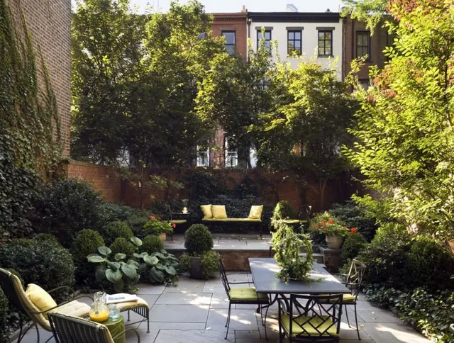 Courtyard seating with ivy and stone, organic, minimal, warm