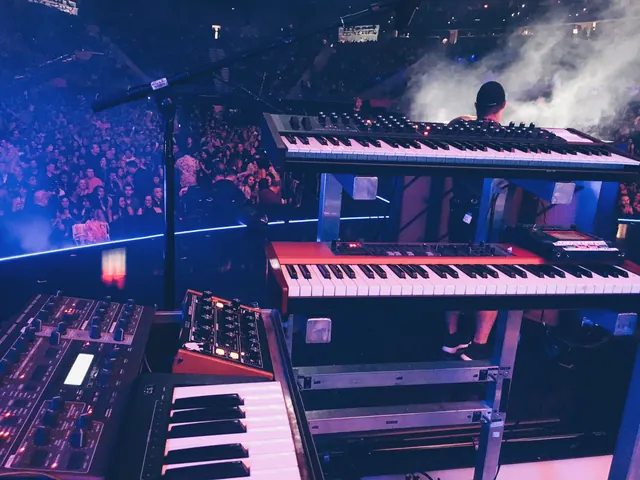 Concert stage with synthesizers and crowd, photographic, dark-mode, dark