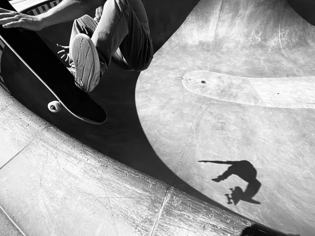 High-contrast black and white skateboarding action, photographic, dark-mode, dark