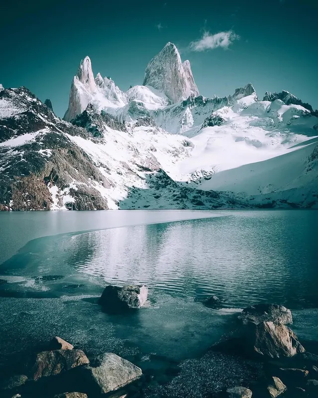 Snow-capped mountain peaks reflected in glacial lake, photographic, cool
