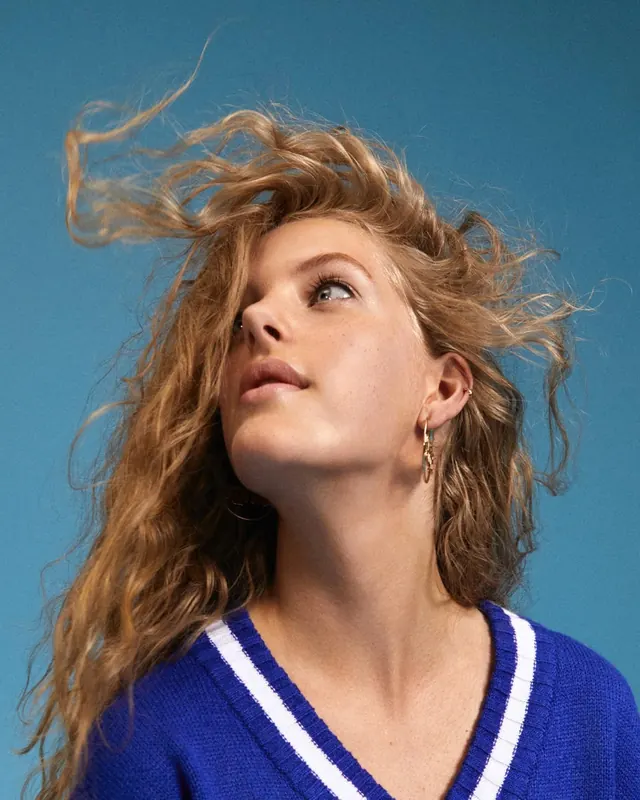 Portrait with windswept hair and blue sweater, photographic, cool