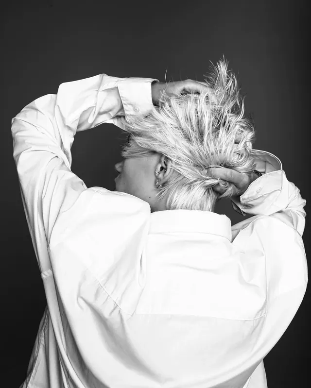 Person with flowing hair in white shirt, photographic, minimalist, light