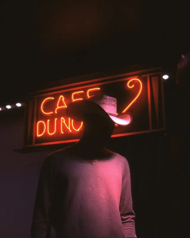 Neon sign with figure silhouette, dark-mode, playful, dark