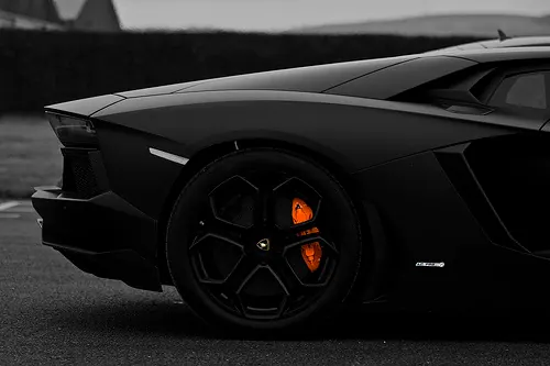 Black sports car detail with orange caliper, minimal, monochrome, dark