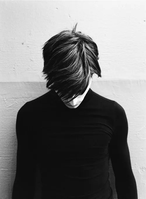 Black and white portrait with tousled hair, photographic, dark-mode, monochrome