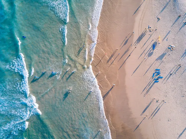 Aerial beach photograph with swimmers, photographic, minimal, cool