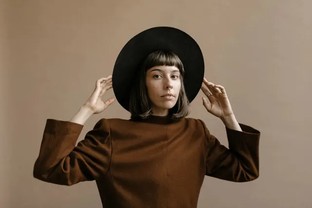 Portrait with black hat and brown shirt, minimal, photographic, light