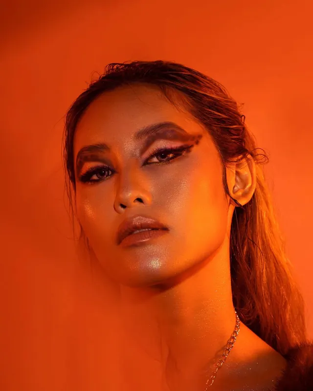 Bold orange beauty portrait with graphic makeup, photographic, bold, vibrant