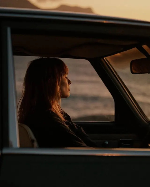 Woman in car window golden hour portrait, photographic, warm, warm