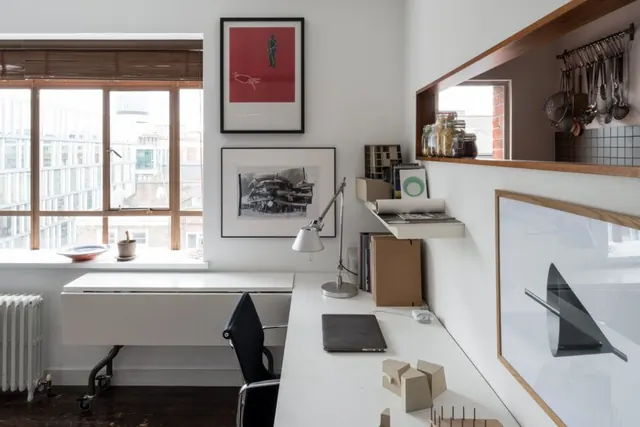 Warm-wood office workspace with gallery wall, minimal, corporate-clean, monochrome