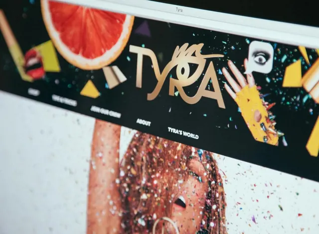 Vibrant TYRA website hero with gold logo and confetti, playful, vibrant, vibrant